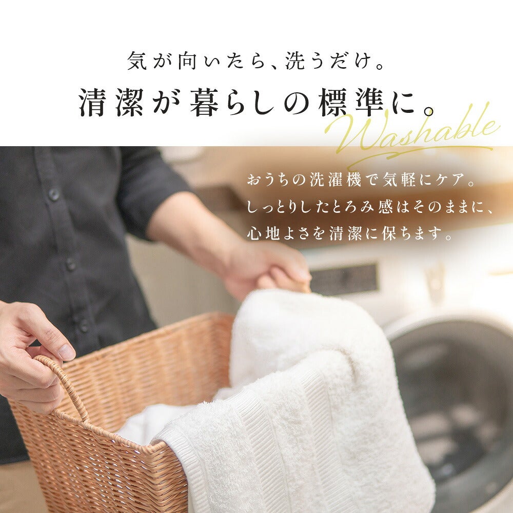 洗濯かごから白いタオル類を取り出す男性の写真。「気が向いたら、洗うだけ。清潔が暮らしの標準に。」の見出し入り（掛け布団カバーと共通の案内画像）