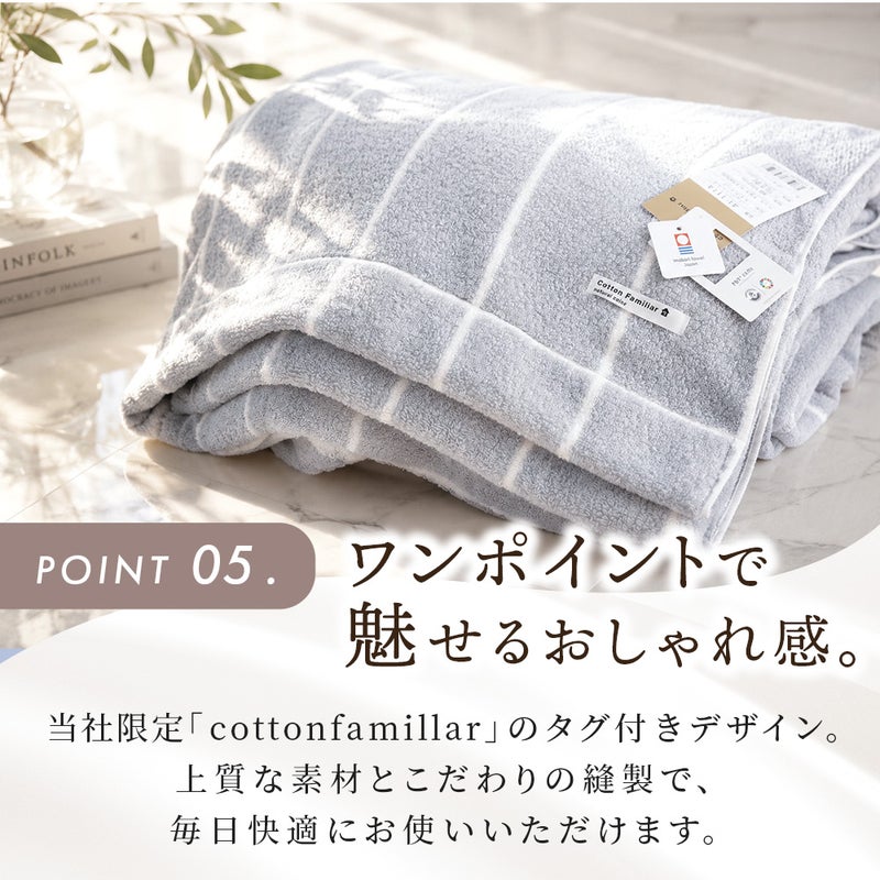 綺麗に折りたたまれた今治タオルケットのグレーと、限定ブランドタグのアップ。「POINT 05. ワンポイントで魅せるおしゃれ感。当社限定『cottonfamiliar』のタグ付きデザイン。上質な素材とこだわりの縫製で、毎日快適にお使いいただけます。」ねごこち本舗