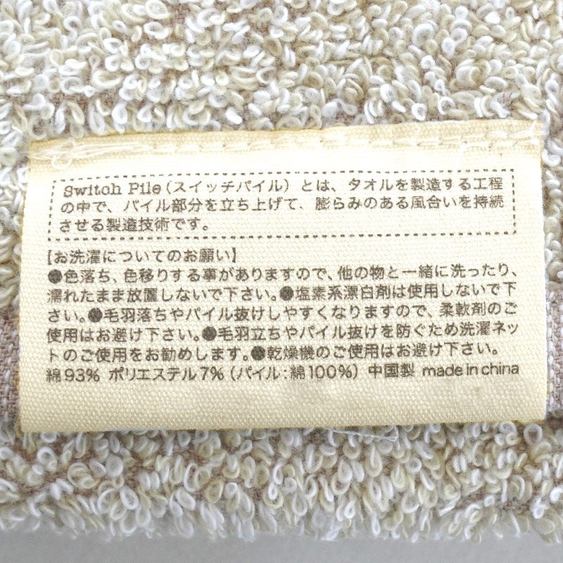 ピンク系タオルの重なりと、パイル生地に指で触れているアップ写真の組み合わせ