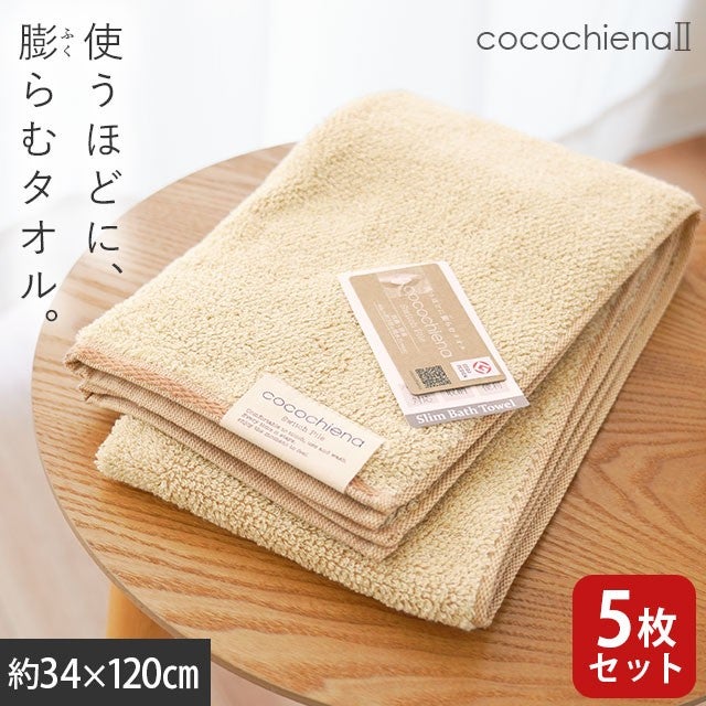 cocochiena2 スリムバスタオル 5枚セット カラー:オレンジ5枚 を畳んで木製テーブルに置いた商品写真（約34×120cm）
