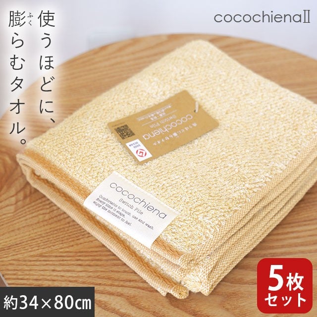 cocochiena2 フェイスタオル 5枚セット カラー:オレンジ5枚 を畳んで木製テーブルに置いた商品写真（約34×80cm）