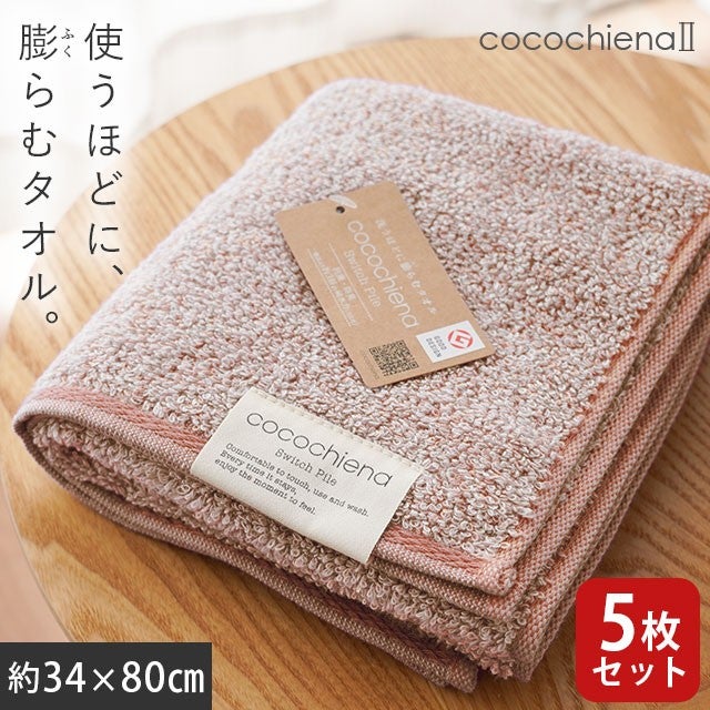 cocochiena2 フェイスタオル 5枚セット カラー:ピンク5枚 を畳んで木製テーブルに置いた商品写真（約34×80cm）