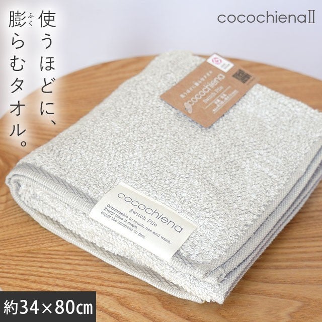 cocochiena2 フェイスタオル カラー:グレー を畳んで木製テーブルに置いた商品写真（約34×80cm）