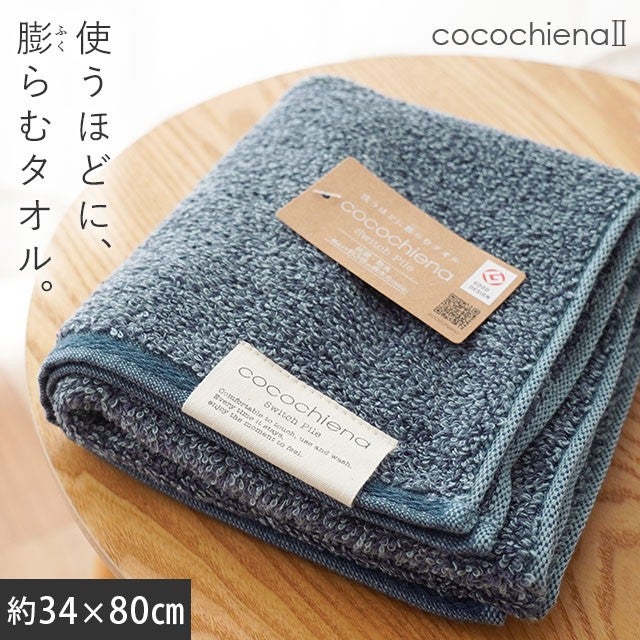 cocochiena2 フェイスタオル カラー:ネイビー を畳んで木製テーブルに置いた商品写真（約34×80cm）