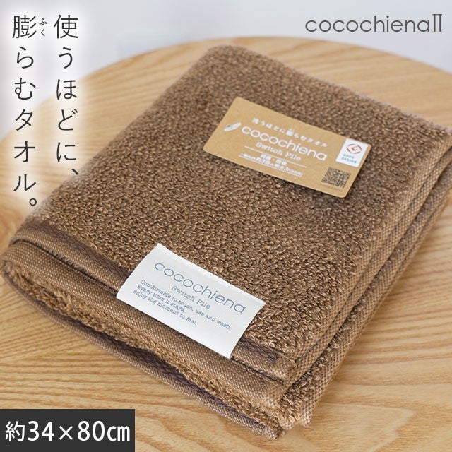 cocochiena2 フェイスタオル カラー:ブラウン を畳んで木製テーブルに置いた商品写真（約34×80cm）