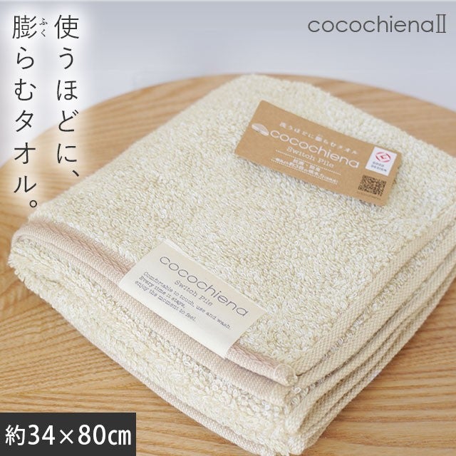 cocochiena2 フェイスタオル カラー:アイボリー を畳んで木製テーブルに置いた商品写真（約34×80cm）