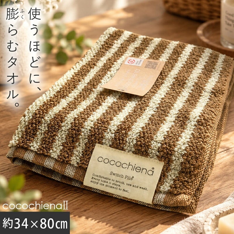 cocochiena2 フェイスタオル カラー:ライン柄/ブラウン を畳んで木製テーブルに置いた商品写真（約34×80cm）
