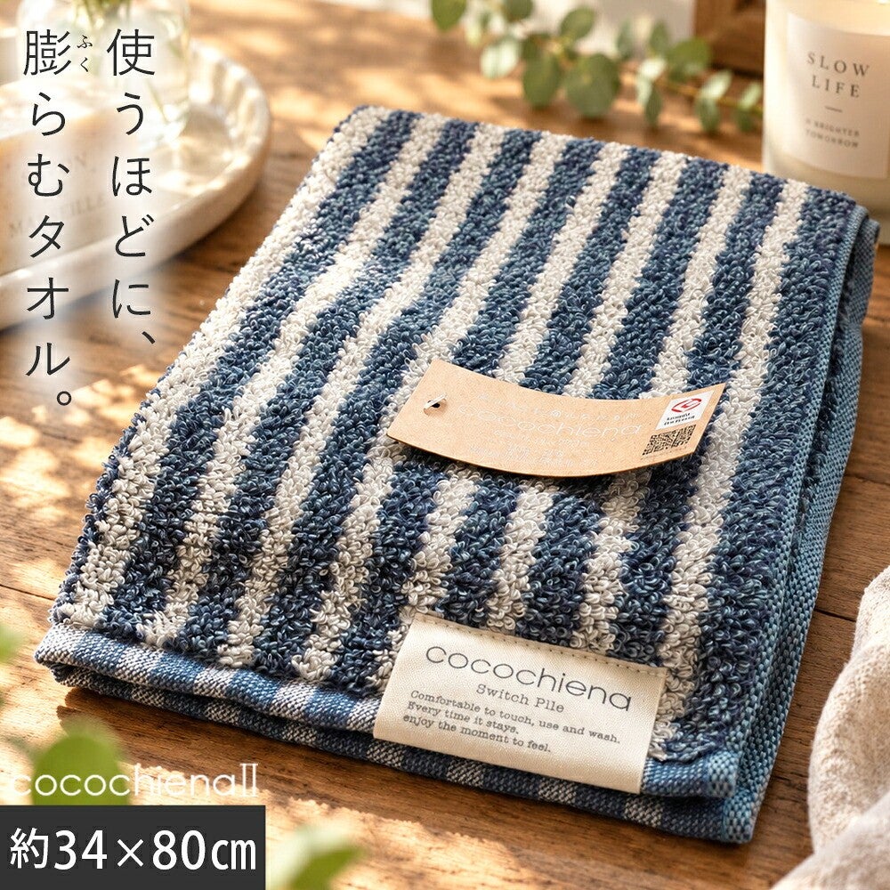 cocochiena2 フェイスタオル カラー:ライン柄/ネイビー を畳んで木製テーブルに置いた商品写真（約34×80cm）