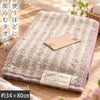 cocochiena2 フェイスタオル カラー:ライン柄/ピンク を畳んで木製テーブルに置いた商品写真（約34×80cm）