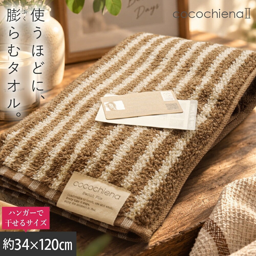 cocochiena2 スリムバスタオル カラー:ライン柄/ブラウン を畳んで木製テーブルに置いた商品写真（約34×120cm）