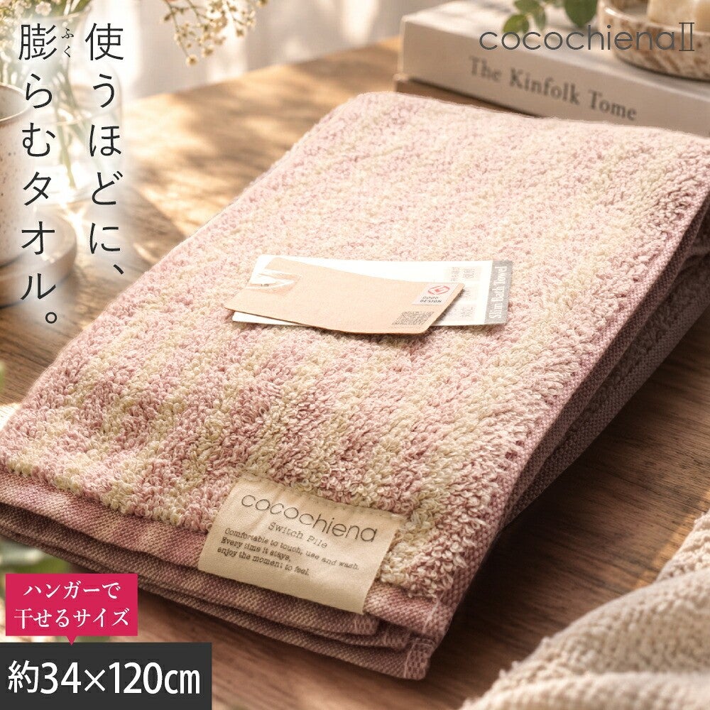 cocochiena2 スリムバスタオル カラー:ライン柄/ピンク を畳んで木製テーブルに置いた商品写真（約34×120cm）