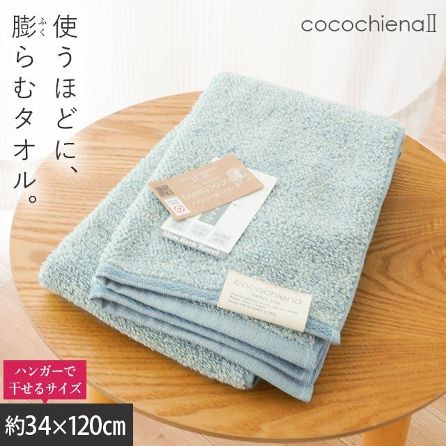 cocochiena2 スリムバスタオル カラー:ブルー を畳んで木製テーブルに置いた商品写真（約34×120cm）