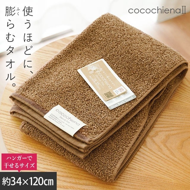 cocochiena2 スリムバスタオル カラー:ブラウン を畳んで木製テーブルに置いた商品写真（約34×120cm）