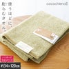 cocochiena2 スリムバスタオル カラー:グリーン を畳んで木製テーブルに置いた商品写真（約34×120cm）