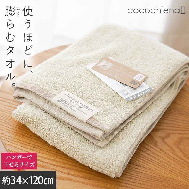 cocochiena2 スリムバスタオル カラー:アイボリー を畳んで木製テーブルに置いた商品写真（約34×120cm）