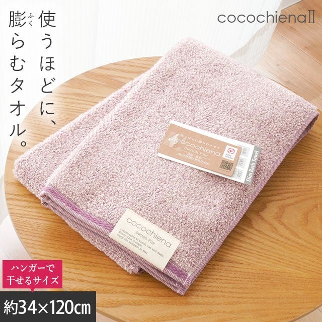 cocochiena2 スリムバスタオル カラー:ピンク を畳んで木製テーブルに置いた商品写真（約34×120cm）