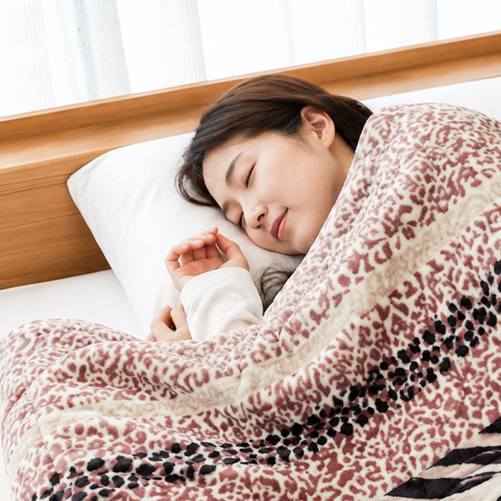 ゼブラ×ヒョウ柄の大判毛布にくるまって眠る女性