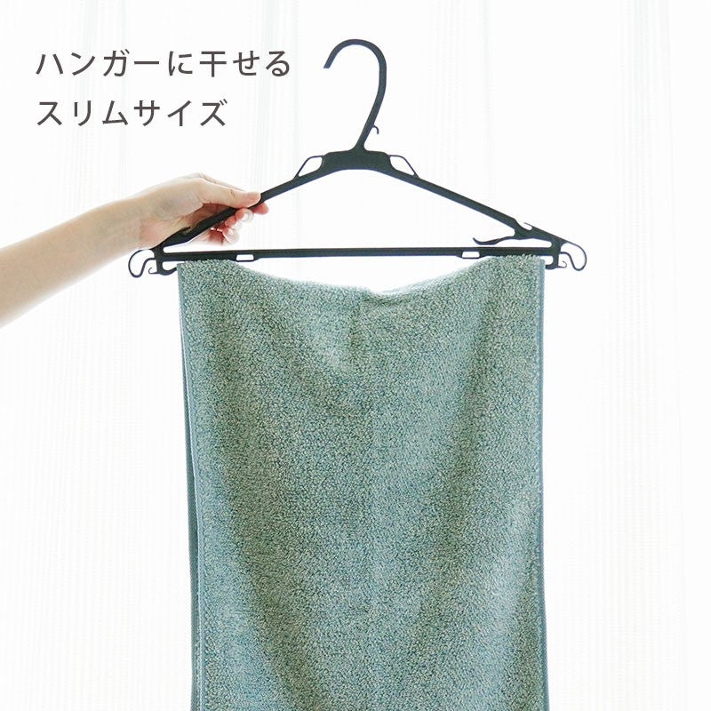 ハンガーにかけた緑色のスリムバスタオルと「ハンガーに干せるスリムサイズ」訴求バナー