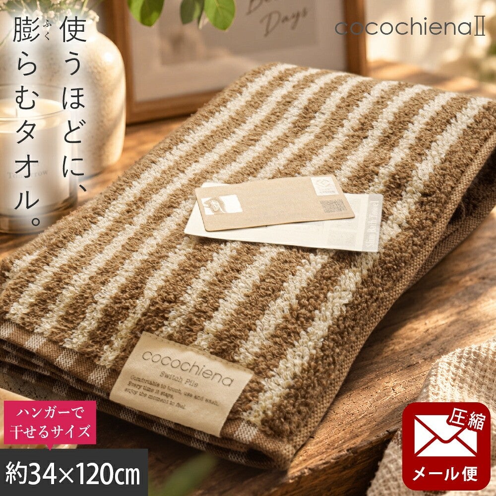 cocochiena2 スリムバスタオル【メール便】 カラー:ライン柄/ブラウン を畳んで木製テーブルに置いた商品写真（約34×120cm）