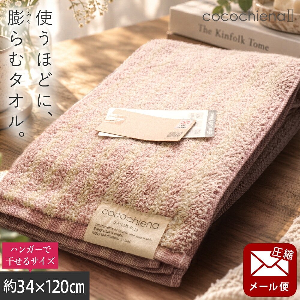 cocochiena2 スリムバスタオル【メール便】 カラー:ライン柄/ピンク を畳んで木製テーブルに置いた商品写真（約34×120cm）