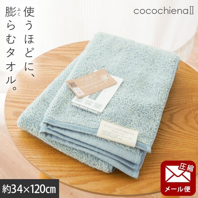 cocochiena2 スリムバスタオル【メール便】 カラー:ブルー を畳んで木製テーブルに置いた商品写真（約34×120cm）