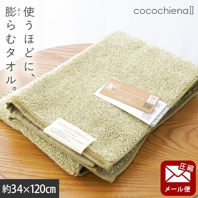 cocochiena2 スリムバスタオル【メール便】 カラー:グリーン を畳んで木製テーブルに置いた商品写真（約34×120cm）
