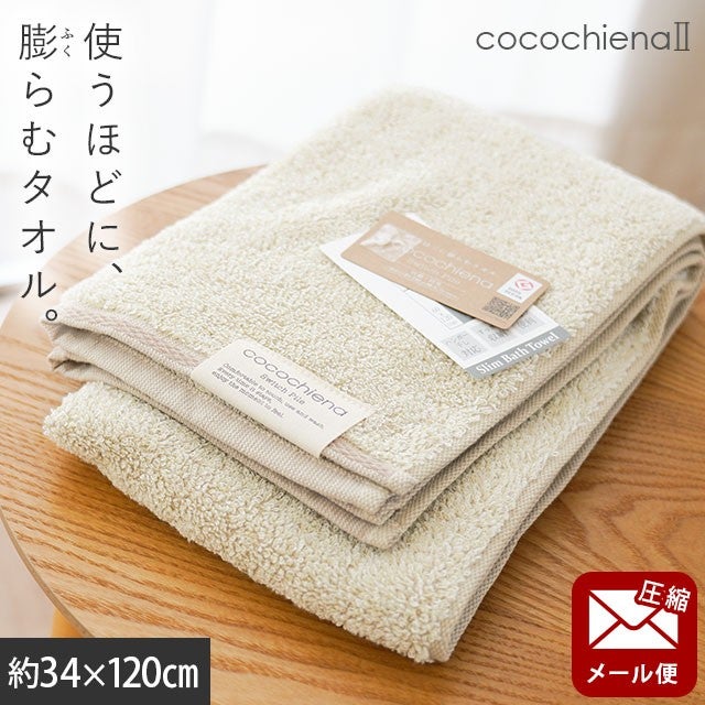 cocochiena2 スリムバスタオル【メール便】 カラー:アイボリー を畳んで木製テーブルに置いた商品写真（約34×120cm）