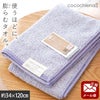 cocochiena2 スリムバスタオル【メール便】 カラー:バイオレット を畳んで木製テーブルに置いた商品写真（約34×120cm）