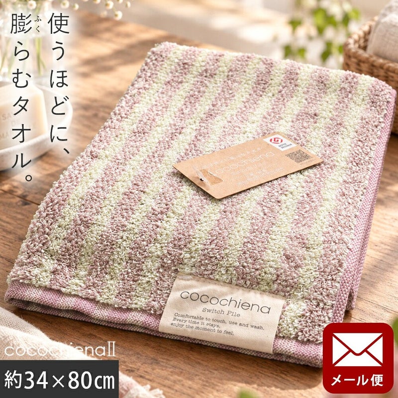 cocochiena2 フェイスタオル【メール便】 カラー:ライン柄/ピンク を畳んで木製テーブルに置いた商品写真（約34×80cm）