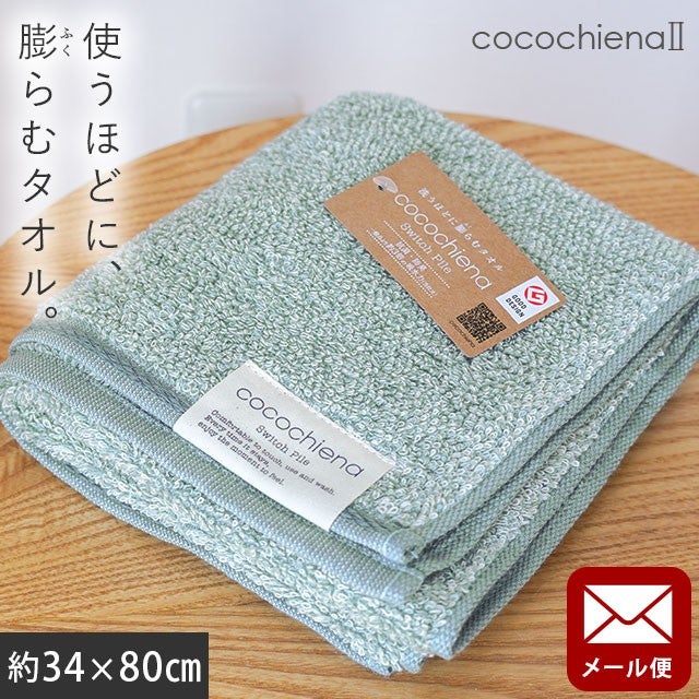 cocochiena2 フェイスタオル【メール便】 カラー:ブルー を畳んで木製テーブルに置いた商品写真（約34×80cm）