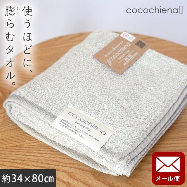 cocochiena2 フェイスタオル【メール便】 カラー:グレー を畳んで木製テーブルに置いた商品写真（約34×80cm）