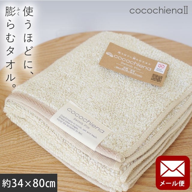 cocochiena2 フェイスタオル【メール便】 カラー:アイボリー を畳んで木製テーブルに置いた商品写真（約34×80cm）