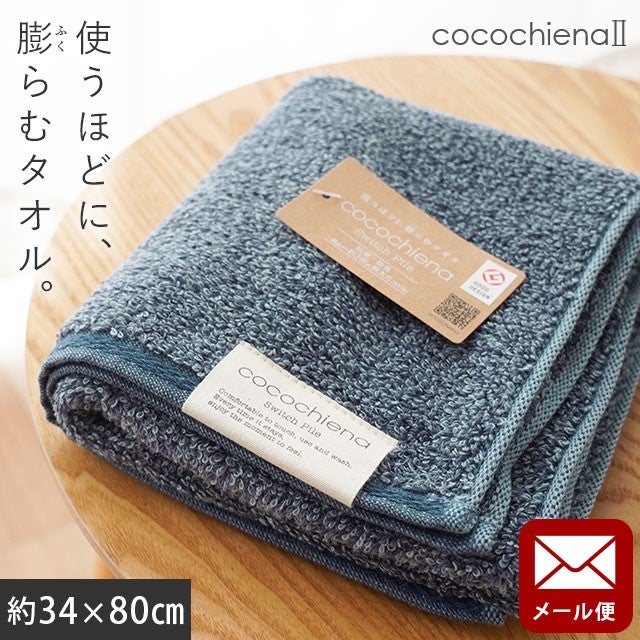 cocochiena2 フェイスタオル【メール便】 カラー:ネイビー を畳んで木製テーブルに置いた商品写真（約34×80cm）