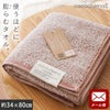 cocochiena2 フェイスタオル【メール便】 カラー:ピンク を畳んで木製テーブルに置いた商品写真（約34×80cm）